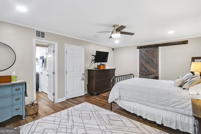 bedroom featuring a barn door, ceiling fan, dark wood-type flooring, and ornamental molding