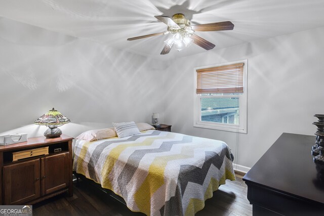 bedroom with dark hardwood / wood-style flooring and ceiling fan