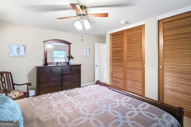 bedroom with ceiling fan and multiple closets