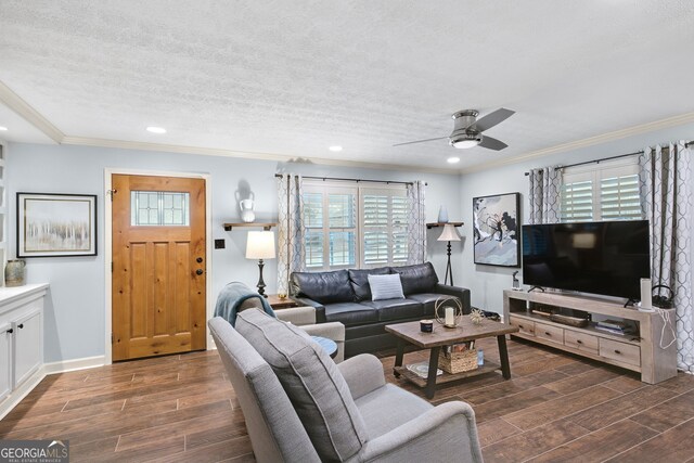 living room with ceiling fan, ornamental molding, and a textured ceiling