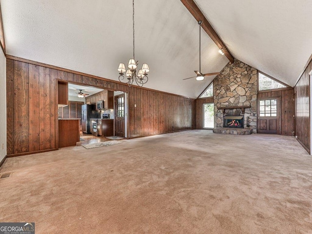 unfurnished living room featuring beamed ceiling, wooden walls, a fireplace, and light carpet