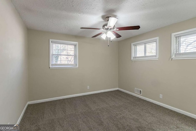 carpeted empty room featuring a textured ceiling