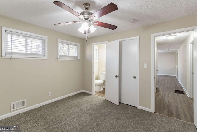 unfurnished bedroom with connected bathroom, ceiling fan, carpet, and a textured ceiling