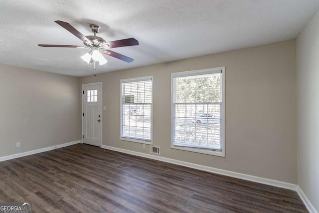 foyer entrance with a textured ceiling, dark hardwood / wood-style flooring, and ceiling fan