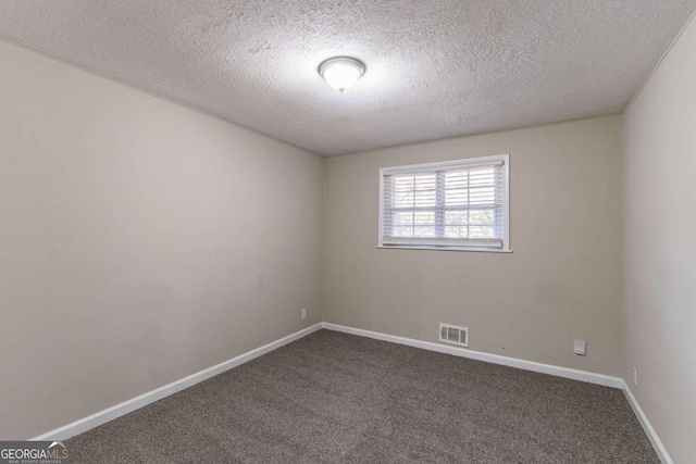 empty room with carpet flooring and a textured ceiling