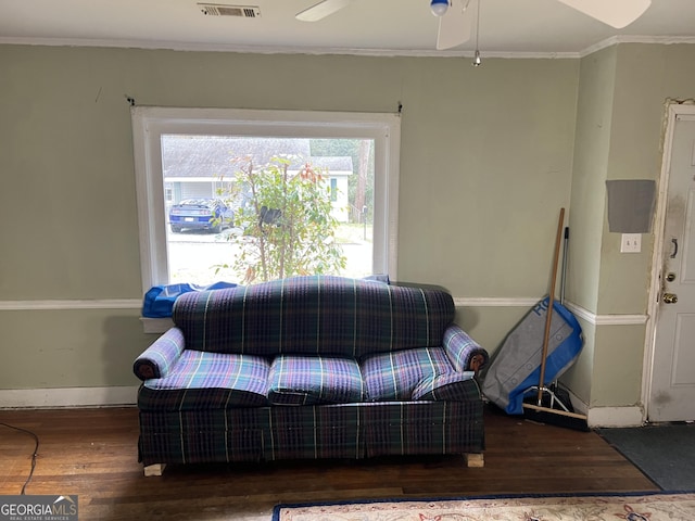 living room with dark hardwood / wood-style floors, ceiling fan, and ornamental molding