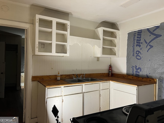 kitchen with white cabinets, range, and sink