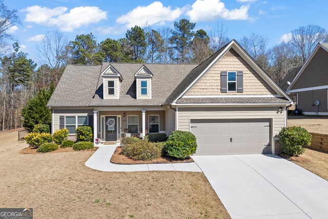 view of front facade with driveway, a shingled roof, and a front yard