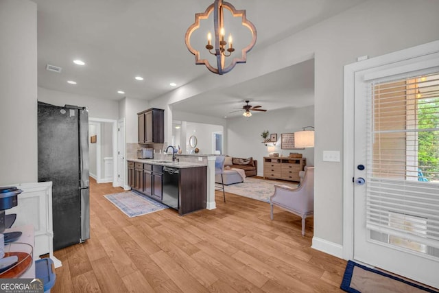 kitchen featuring dishwasher, light wood-style flooring, open floor plan, freestanding refrigerator, and a peninsula