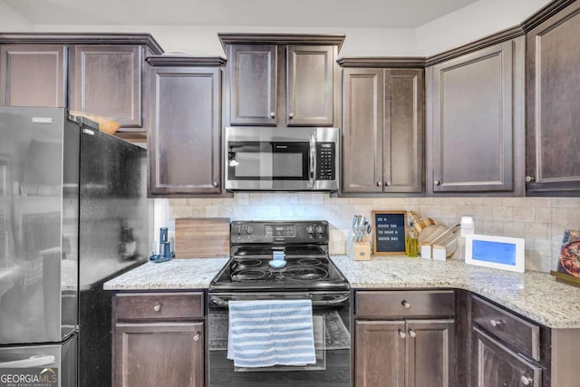 kitchen with stainless steel appliances, dark brown cabinets, light stone counters, and decorative backsplash