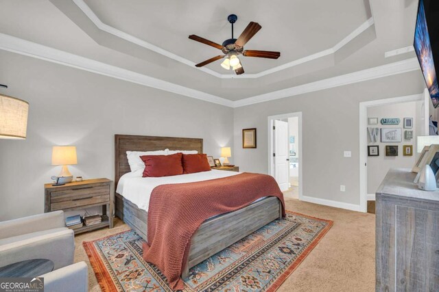 bedroom featuring light carpet, baseboards, a raised ceiling, a ceiling fan, and crown molding