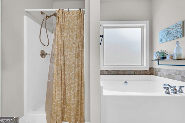 bathroom with a garden tub and a shower stall