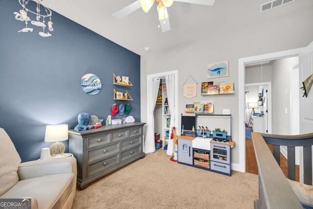 carpeted bedroom featuring attic access, a closet, visible vents, and ceiling fan