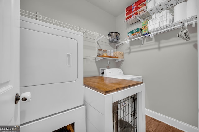 washroom featuring washer / dryer, laundry area, baseboards, and wood finished floors