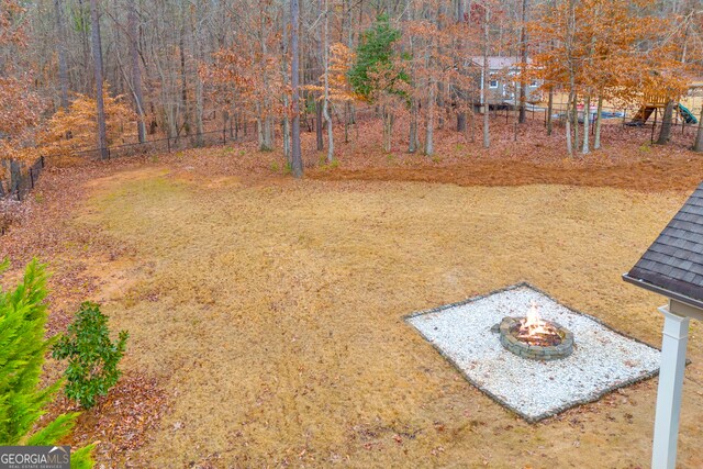 view of yard featuring an outdoor fire pit and playground community