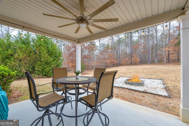 view of patio / terrace with fence, a fire pit, a ceiling fan, and outdoor dining space