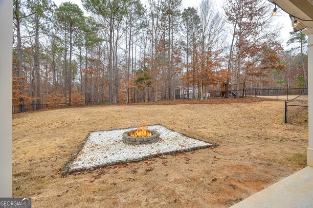 view of yard featuring fence and a fire pit