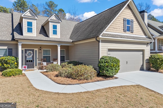 view of front of property featuring a shingled roof, a porch, and concrete driveway