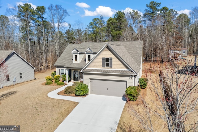 view of front of house featuring a garage, a shingled roof, and concrete driveway