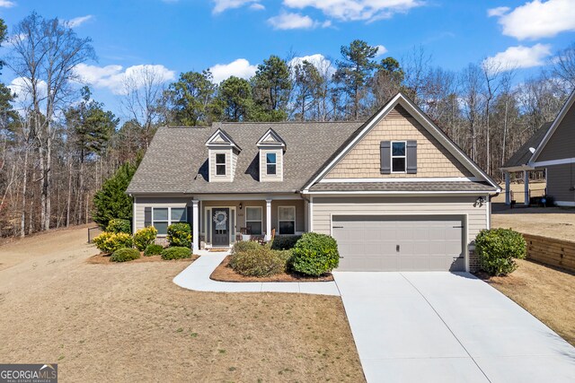 view of front facade with a front yard, roof with shingles, and driveway