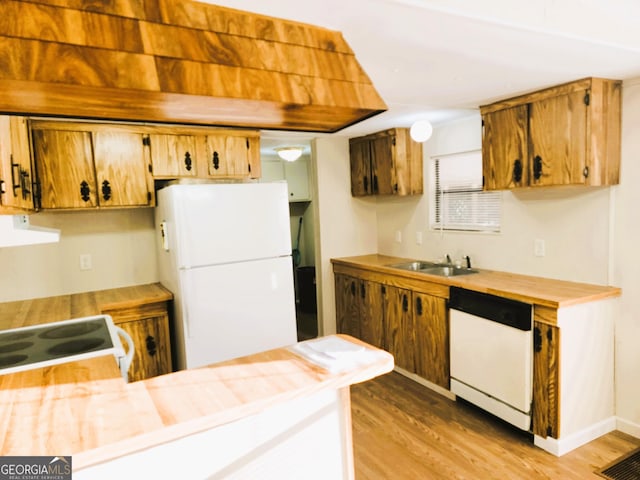 kitchen with white appliances, sink, and light hardwood / wood-style flooring