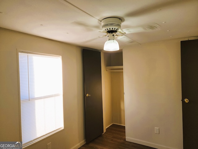 unfurnished bedroom with a closet, ceiling fan, and dark hardwood / wood-style flooring