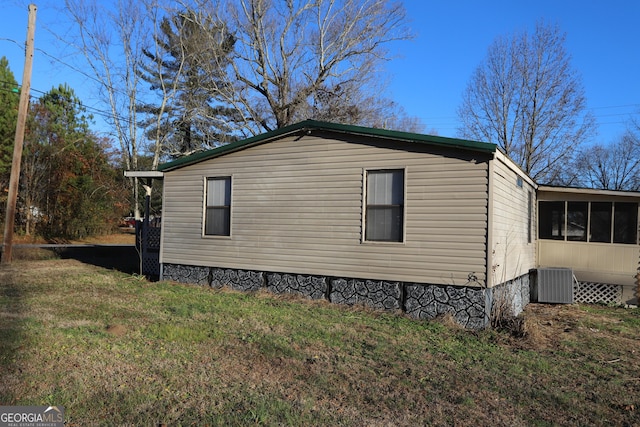 view of property exterior with a lawn, central AC, and a sunroom