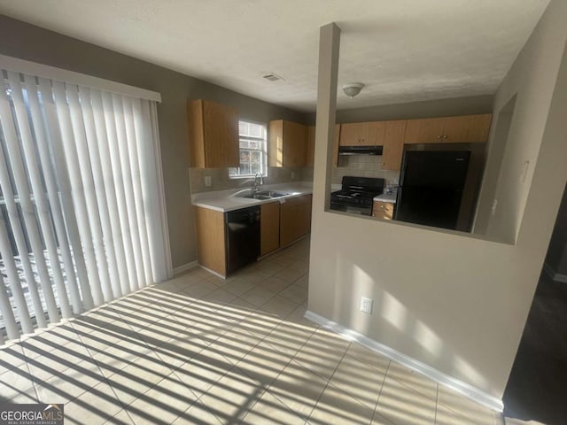 kitchen featuring black appliances, sink, tasteful backsplash, and light tile patterned flooring