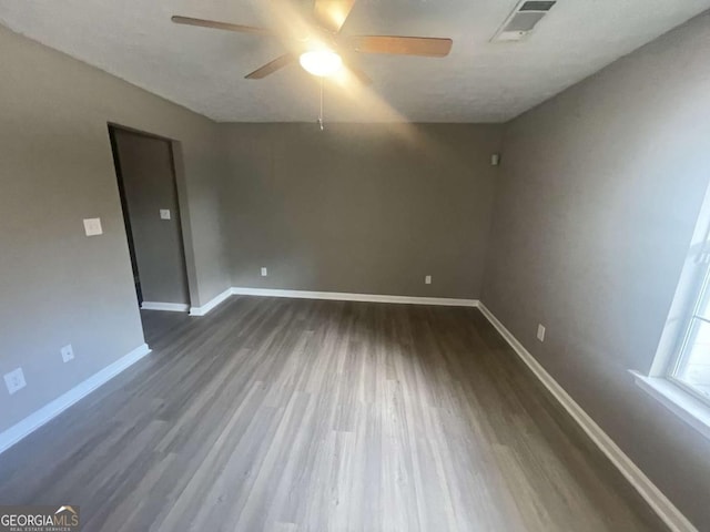 unfurnished room featuring ceiling fan and dark wood-type flooring