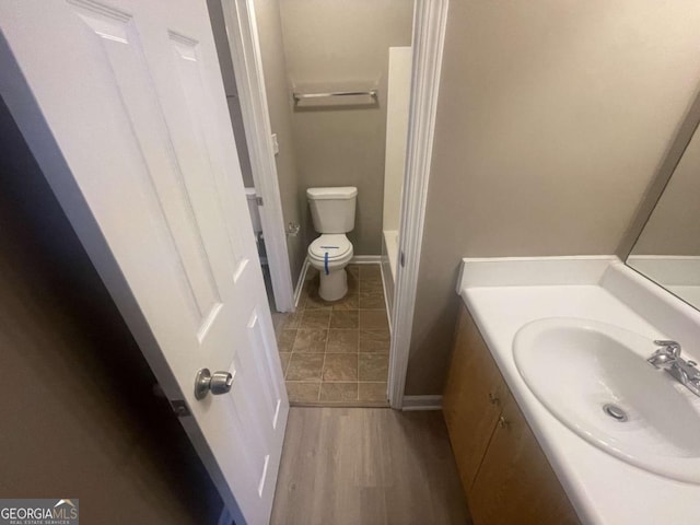 bathroom featuring toilet, hardwood / wood-style flooring, and vanity