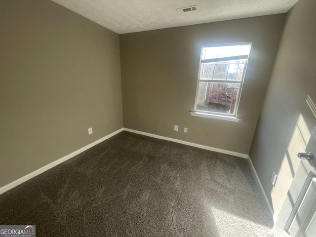 carpeted spare room featuring a textured ceiling