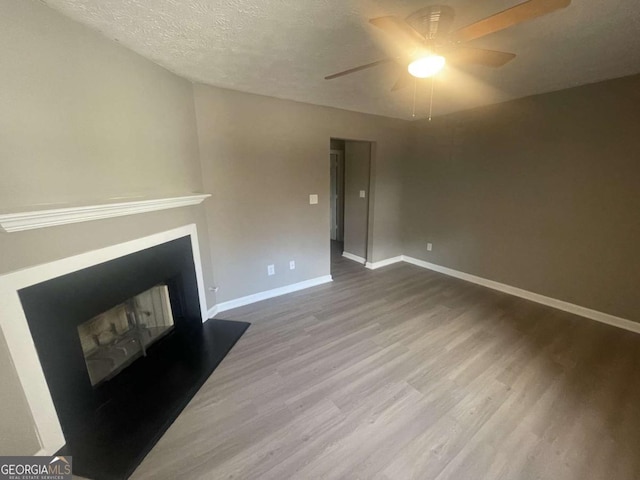 living room featuring hardwood / wood-style flooring, a textured ceiling, and ceiling fan