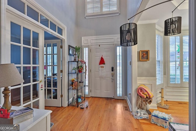 foyer featuring crown molding, hardwood / wood-style floors, and french doors