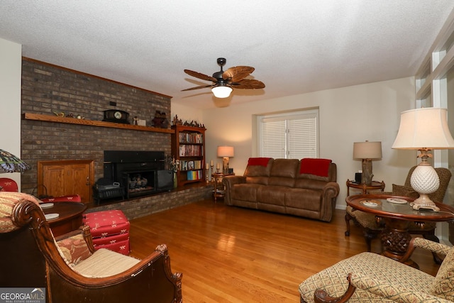 living room with a fireplace, a textured ceiling, and hardwood / wood-style flooring