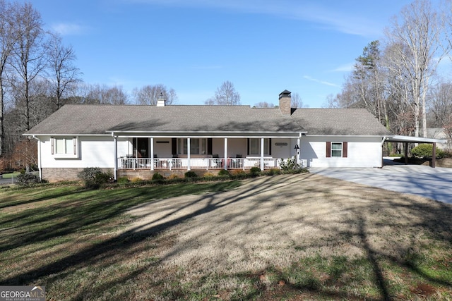 ranch-style home with a carport, covered porch, and a front lawn