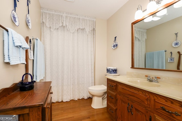 bathroom featuring hardwood / wood-style floors, vanity, and toilet