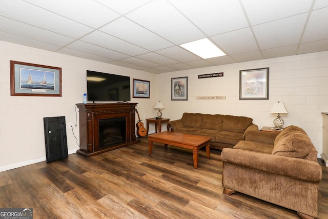 living room with a paneled ceiling and wood-type flooring