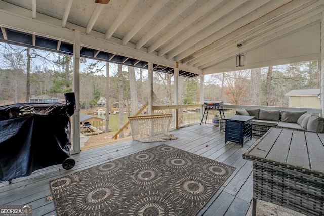 wooden terrace featuring a grill and an outdoor living space