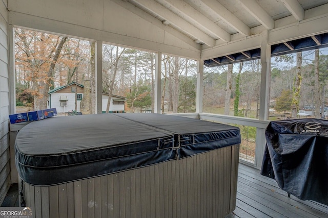 sunroom featuring lofted ceiling and a hot tub