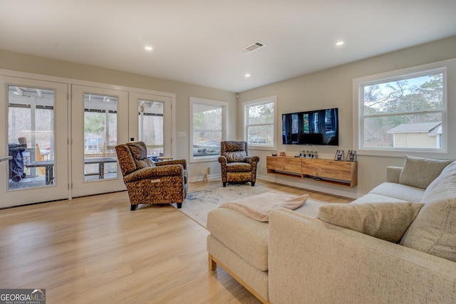 living room with hardwood / wood-style flooring, a healthy amount of sunlight, and french doors