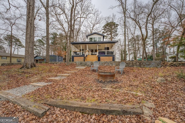 view of front of home featuring a porch and an outdoor fire pit