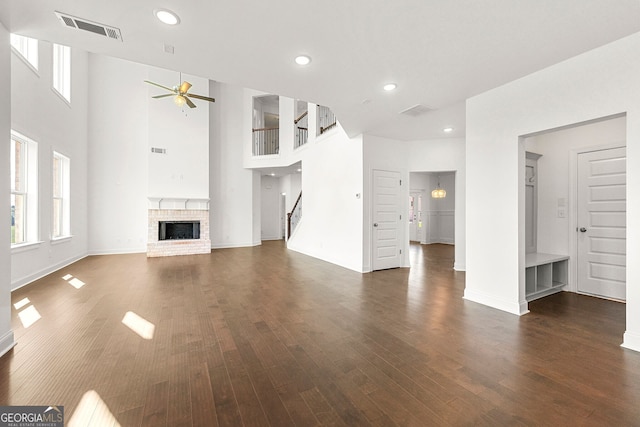 unfurnished living room featuring ceiling fan, dark hardwood / wood-style floors, and a fireplace