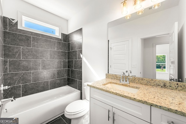 full bathroom with tile patterned flooring, vanity, tiled shower / bath combo, and toilet