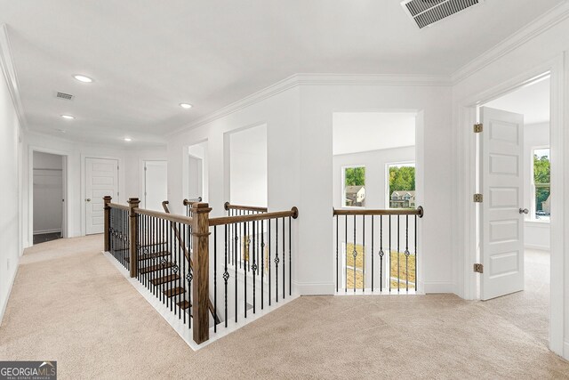 hall with light colored carpet and ornamental molding