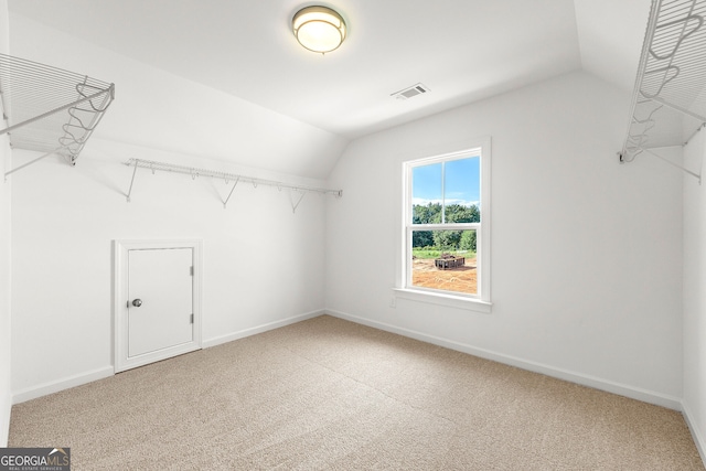 walk in closet featuring carpet floors and lofted ceiling