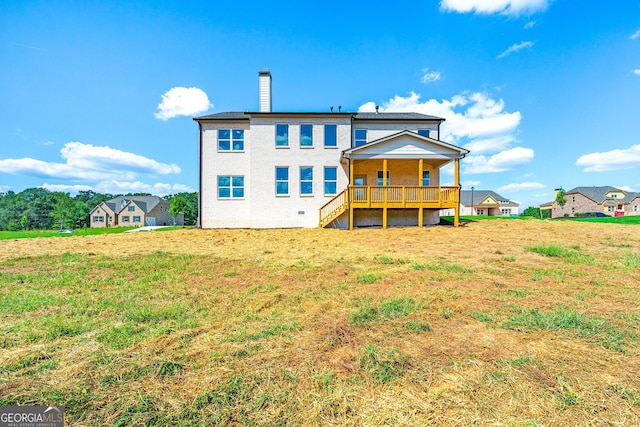 back of house with a lawn and a deck