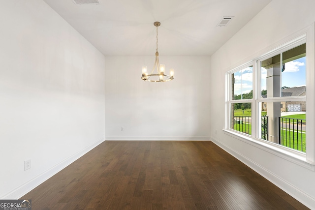 unfurnished room featuring a chandelier and dark hardwood / wood-style floors