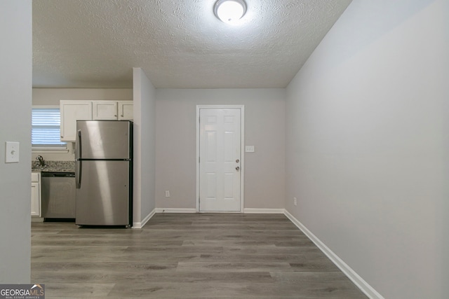 2098 Mallard Crst, Lithonia, GA 30058 - kitchen with sink, appliances with stainless steel finishes, light hardwood / wood-style floors, and white cabinetry