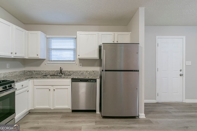 2098 Mallard Crst, Lithonia, GA 30058 - kitchen featuring light stone counters, light wood-type flooring, white cabinets, appliances with stainless steel finishes, and sink