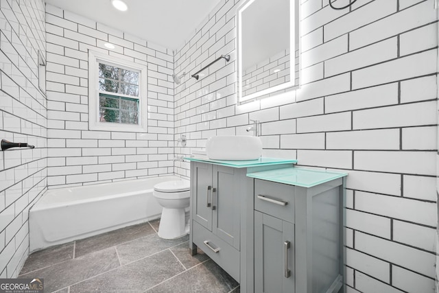 full bathroom with vanity, toilet, tile walls, and tiled shower / bath combo